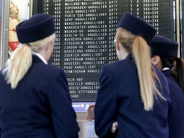 Funcionários da Lufthansa diante do painel do Aeroporto de Frankfurt. (Foto: Michael Probst / AP Photo)