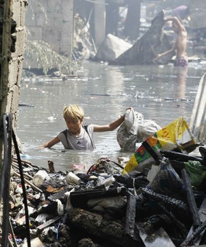 Jovem tenta recuperar objetos após fogo destruir favela nas Filipinas (Romeo Ranoco/Reuters)