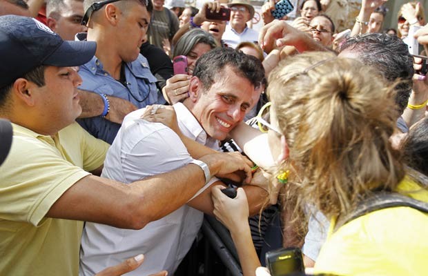 O candidato oposicionista à presidência da Venezuela, Henrique Capriles, é saudado ao votar neste domingo (7) (Foto: AFP)