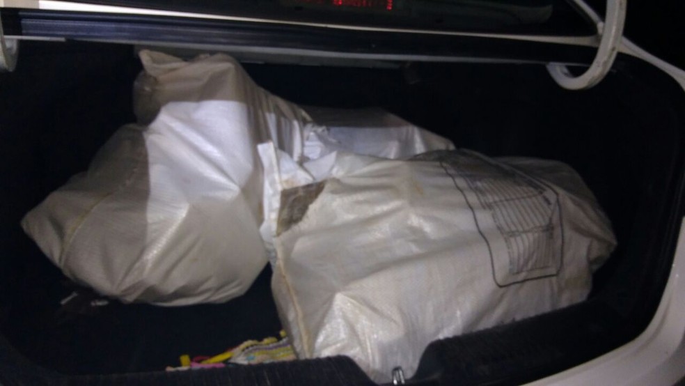 Tijolos de maconha foram encontrados no bagageiro do sedã. Motorista perdeu o controle da direção, capotou e abandonou o veículo (Foto: Polícia Militar/Divulgação)