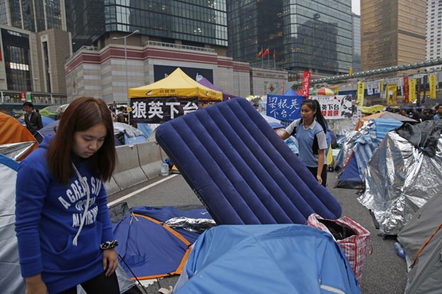 Manifestantes juntam suas coisas em acampamento de protesto estudantil em Hong Kong nesta quarta-feira (10) (Foto: Kin Cheung/AP)