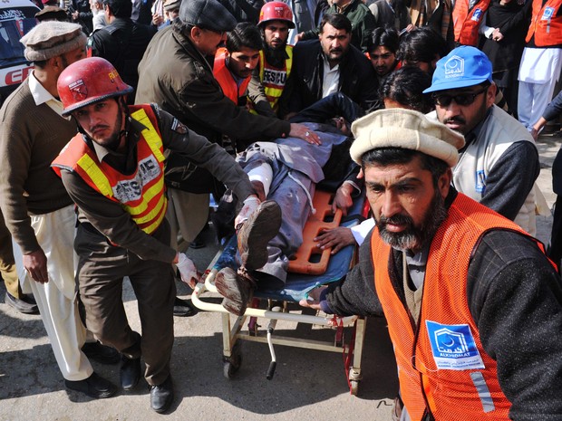 Equipes de resgate carregam ferido em ataque a universidade no Paquistão nesta quarta-feira (20) (Foto: Hasham Ahmed/AFP)