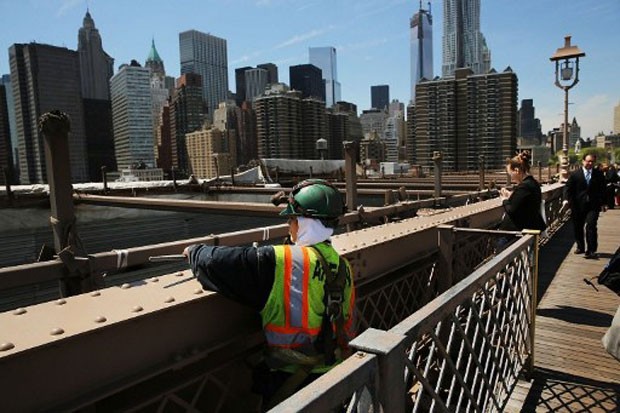 Operários podem ser vistos diariamente na ponte do Brooklyn, em Nova York, que passa por readequações para receber melhor pedestres e motoristas (Foto: Spencer Platt/Getty Images/AFP)