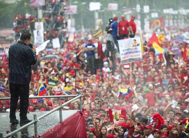 Debaixo de chuva, Chávez discursa no último comício antes das eleições, nesta quinta-feira (4), em Caracas (Foto: Juan Barreto / AFP)