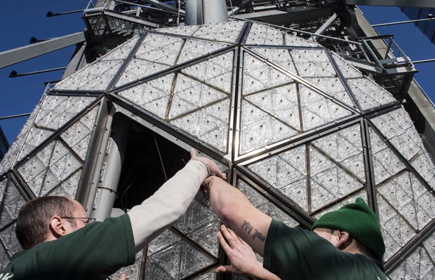 Funcionários instalam um dos 288 triângulos de cristal na bola de ano novo da Times Square, neste sábado (27). A bola cai a meia-noite do dia 31 na famosa rua da cidade americana, para comemorar a passagem do ano (Foto: Stephanie Keith/Reuters)