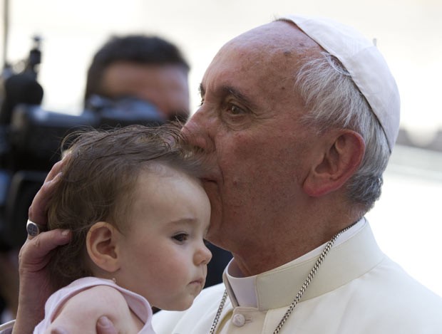 O Papa Francisco beija criança nesta quarta-feira (20) na Praça de São Pedro, no Vaticano (Foto: AP)
