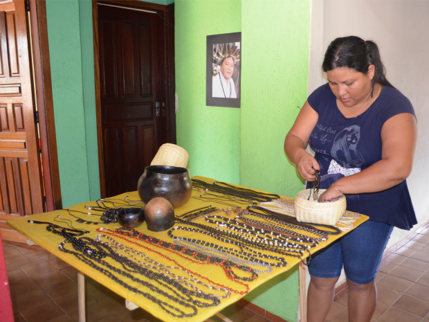 Maria organiza as mercadorias na banca para exposiçao (Foto: Paula Casagrande/G1)