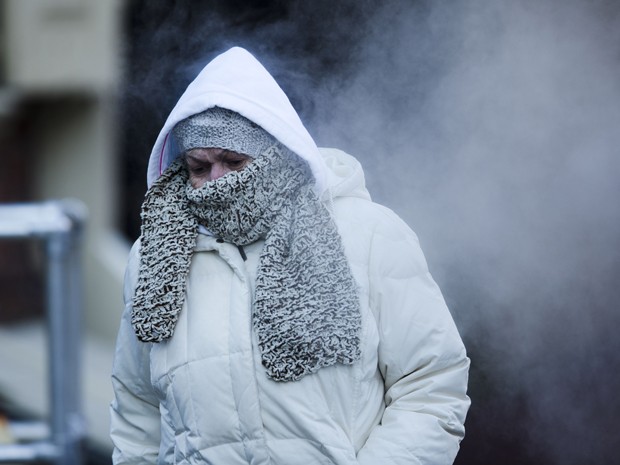 Mulher cobre o rosto para se proteger do frio perto do Market Street, na Filadélfia (Foto: AP Photo/Matt Rourke)