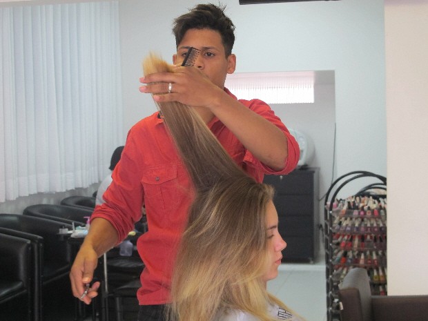 Cabeleireiro Jonathan Coutinho cortando o cabelo seco de uma cliente (Foto: Mariane Rossi/G1)