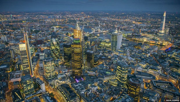  O fotógrafo Jason Hawkes, que sobrevoa Londres regularmente em um helicóptero AS355, divulgou uma série de fotos da cidade, incluindo esta imagem aérea noturna dos novos arranha-céus da capital britânica.  (Foto: Jason Hawkes)