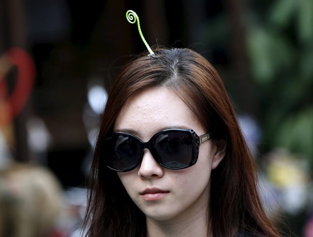 Mulheres têm usado grampos no formato de flores e plantas no cabelo (Foto: Kim Kyung-hoon/Reuters) Mulheres têm usado grampos no formato de flores e plantas no cabelo (Foto: Kim Kyung-hoon/Reuters)