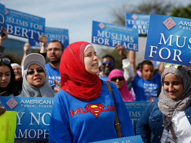 Mulheres muçulmanas protestam neste sábado (5) em frente ao local de comício de Donald Trump em Orlando, na Flórida, com cartazes "Muçulmanos pela paz". (Foto: AP Photo/Brynn Anderson)