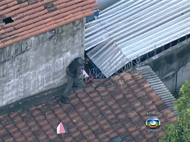 Policiais sobem em telhado para montar cerco a assaltantes no Lins (Foto: Reprodução / TV Globo)