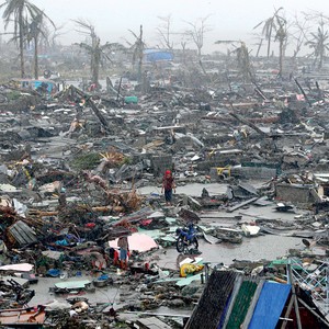 DEVASTAÇÃO Morador caminha sobre destroços em Tacloban.  O Haiyan  destruiu 90% da cidade, com ventos de mais de 300 km/h (Foto: Erik De Castro/Reuters)