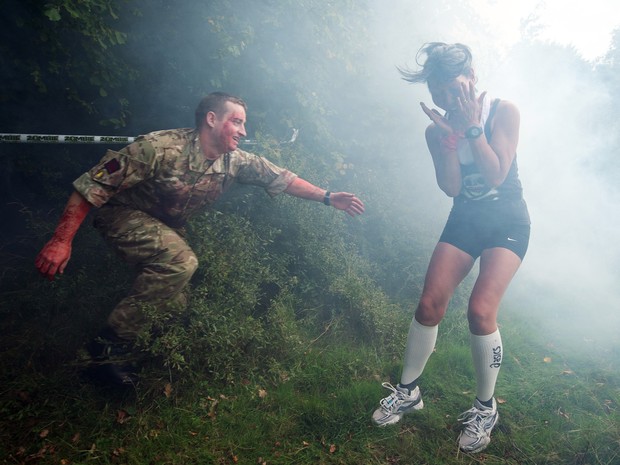 Homem vestido de &quot;zumbi&quot; tenta &quot;infectar&quot; participante de corrida no Reino Unido (Foto: LEON NEAL / AFP)