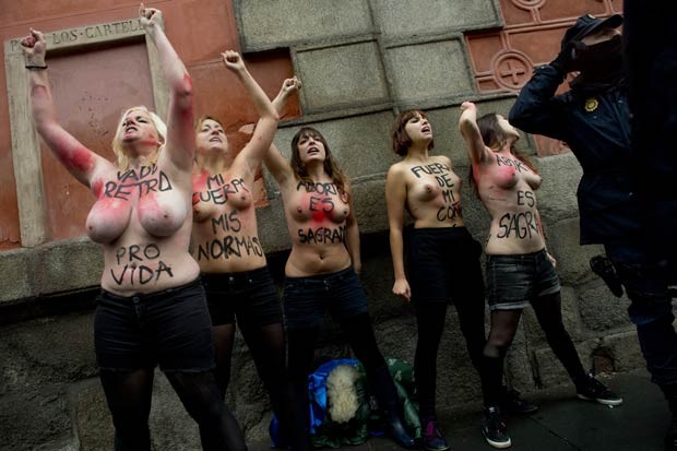 Mulheres protestam de topless diante de marcha antiaborto em Madri neste domingo (17) (Foto: Pierre-Philippe Marcou/AFP)