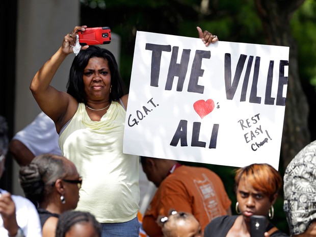 Espectadores carregavam cartazes ou flores e gritavam o nome de Ali (Foto: Michael Conroy/AP)