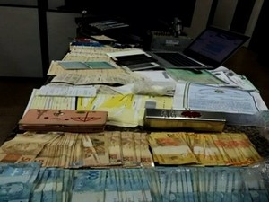 Polícia apreendeu com suspeito dinheiro, drogas, arma, cheques e diversos documentos (Foto: Reprodução/TV Anhanguera)