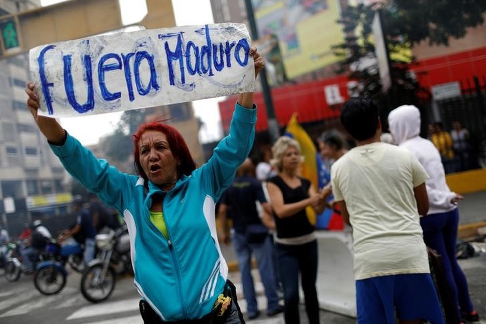 Manifestante da oposição segura cartaz que diz 'Fora Maduro', durante protesto em Caracas (Foto: REUTERS/Carlos Garcia Rawlins)