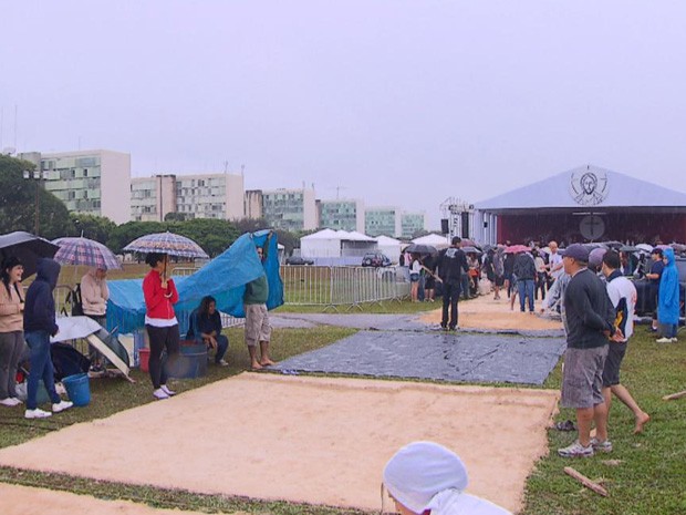Jovens participam de montagem dos tapetes sob chuva na Esplanada dos Ministérios,em Brasília (Foto: Reprodução/TV Globo)