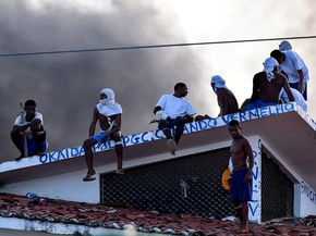 19/01 - Presos são vistos no telhado durante uma rebelião na penitenciária de Alcaçuz, perto de Natal, no Rio Grande do Norte (Foto: Josemar Gonçalves/Reuters)