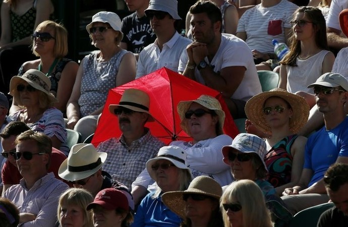 Torcida se protege do sol em Wimbledon (Foto: Reuters)