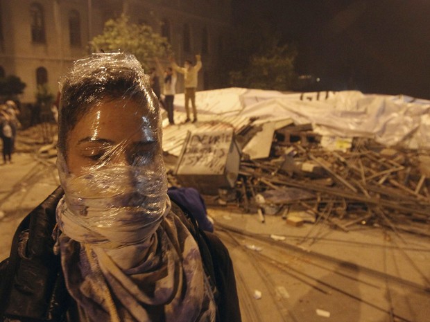 3 de junho - Manifestante cobre o rosto com plástico para se proteger de bombas de gás lacrimogênio durante confronto com a polícia em Istambul. (Foto: Thanassis Stavraki/AP)