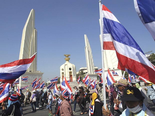 Manfiestantes marcham em frente ao Monumento para a Democracia na Tailândia em meio aos protestos que pedem a deposição do governo, considerado corrupto. (Foto: Sakchai Lalit/AP)