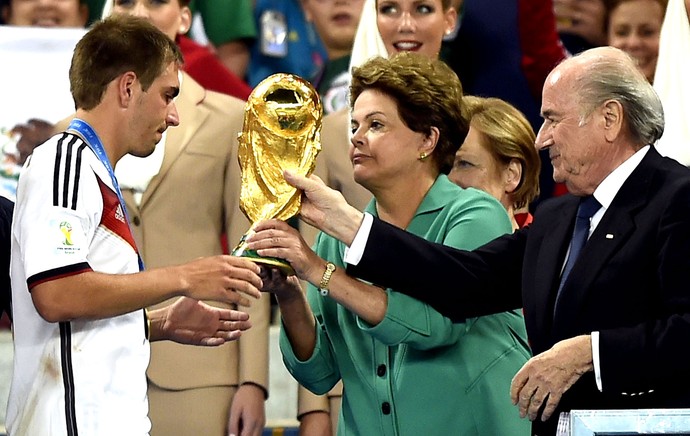 Philipp Lahm recebe a taça da Copa do Mundo das mãos da Dilma (Foto: AFP)