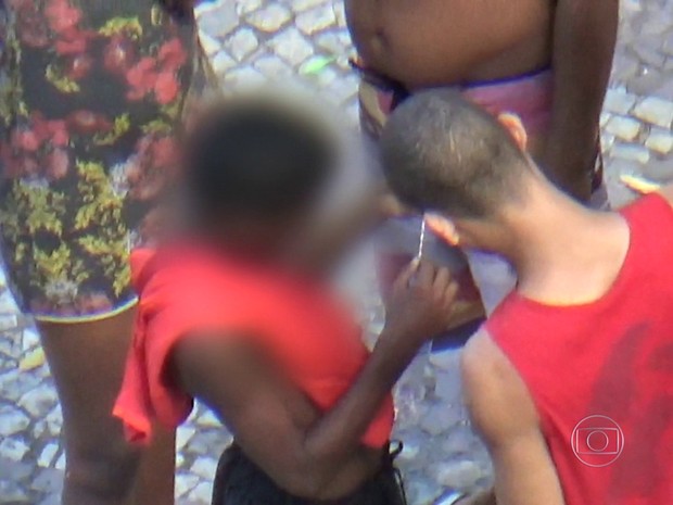 Assaltantes avaliam cordão roubado (Foto: Reprodução/ TV Globo)