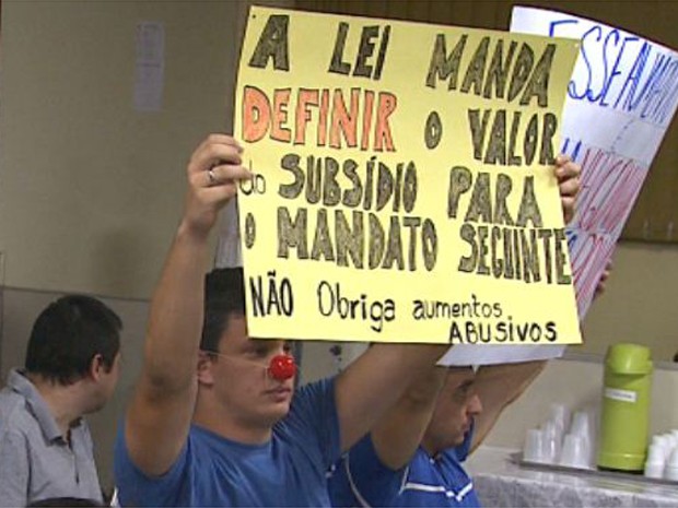 Manifestante carrega cartaz com críticas ao rejuste de 25,6% no salário dos vereadores (Foto: César Tadeu/EPTV)