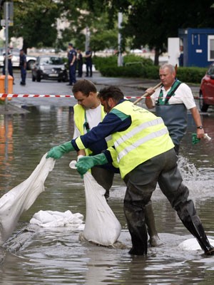 Homens tentam barrar águas após forte tempestade em Budapeste (Foto: FERENC ISZA/AFP)