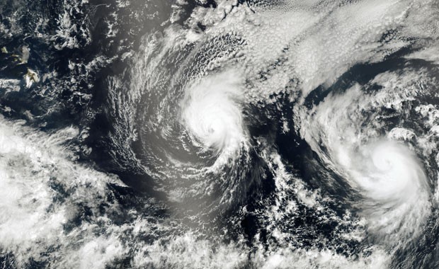 Imagem composta a partir de fotos de satélite feitas na terça-feira (5) mostra do espaço os furacões Iselle (centro) e Julio (dir.), que seguem em direção ao Havaí. Espera-se que o Iselle atinja as ilhas havaianas nesta quinta-feira (7) (Foto: AFP/Nasa Earth Observatory)