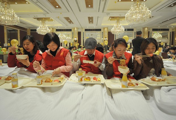 Grupo estabeleceu um novo recorde mundial para o maior número de pessoas tomando café da manhã na cama (Foto: Jia Ru/AFP)