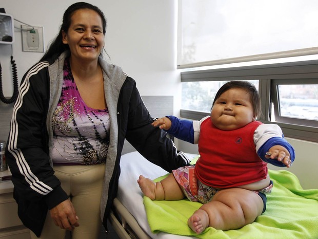 Eunice Fandino posa com seu filho de 8 meses, Santiago Mendoza, em clínica de Bogotá, na Colômbia. A história do menino com sobrepeso, que já pesa mais de 20 kg quando o peso normal seria entre 5 kg e 8 kg, chamou atenção no país e ganhou apoio de uma ONG (Foto: Fernando Vergara/AP)