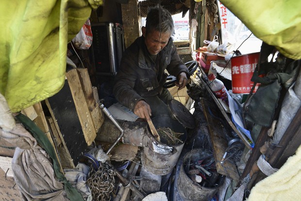 Artista usa gravetos e folhas como combustível para se aquecer dentro de sua 'casa motorizada' (Foto: Stringer/Reuters)