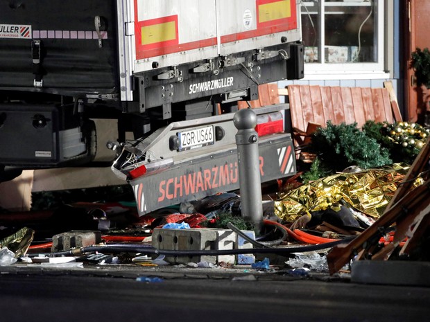 Corpos de vítimas são cobertos por um plástico amarelo ao lado de destroços após um caminhão invadir uma feira de Natal em Berlim, na Alemanha (Foto: Pawel Kopczynki/Reuters)