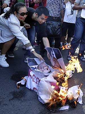 Manifestantes chineses queimam fotos do primeiro-ministro japonês, Yoshihiko Noda, durante protesto perto da Embaixada do Japão em Pequim. (Foto: Ng Han Guan / AP Photo)