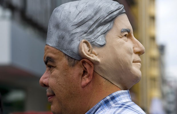 Partidário de Lopez Obrador usa máscara do candidato em comício na Cidade do México, na última quarta-feira (27) (Foto: Alfredo estrella/AFP)