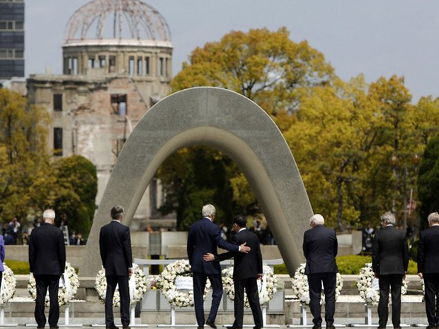 Secretário de Estados dos Estados Unidos, John Kerry, coloca o braço nas costas do ministro de relações exteriores do Japão, Fumio Kishida, durante uma visita ao Memorial de Hiroshima nesta segunda-feira (11). Cidade foi devastada por uma bomba americana (Foto: Jonathan Ernst / AFP)