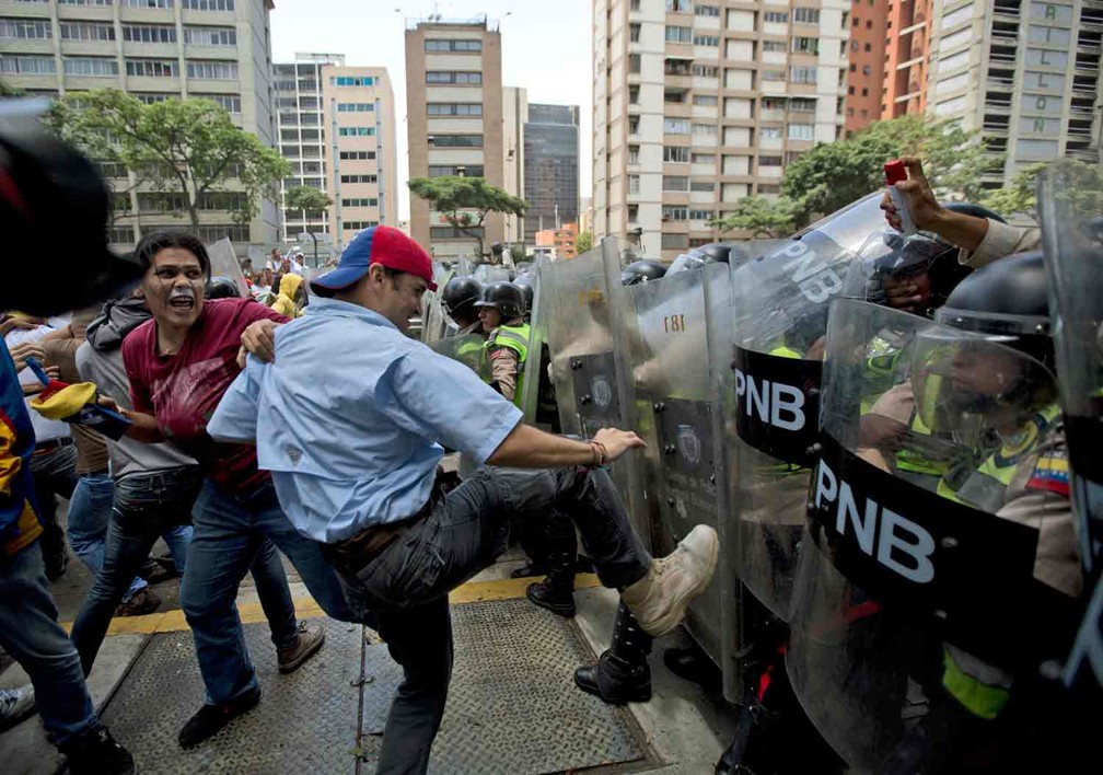 Polícia entra em confronto com opositores do governo em Caracas  (Foto: Fernando Llano/AP)