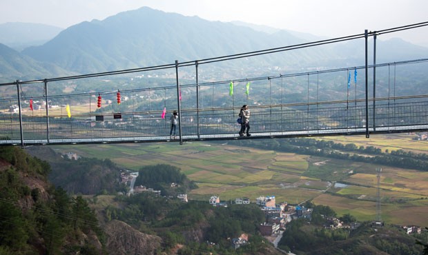 Uma ponte de vidro construída sobre um desfiladeiro a uma altura de 180 metros na China (Foto: Johannes Eisele/AFP)