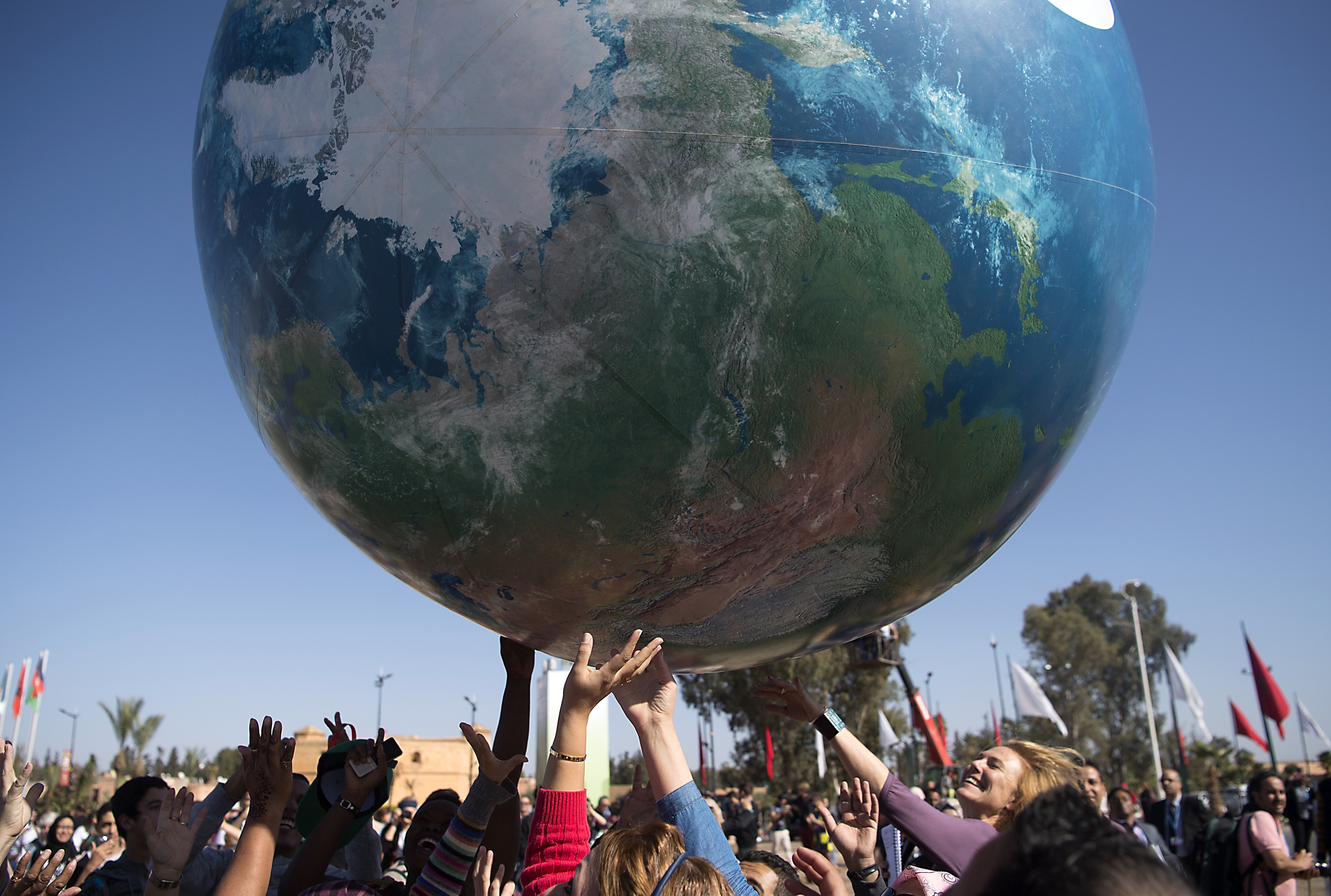 Membros das delegações internacionais brincam com globo gigante nesta sexta-feira (18) fora da COP22, em Marrakesh
