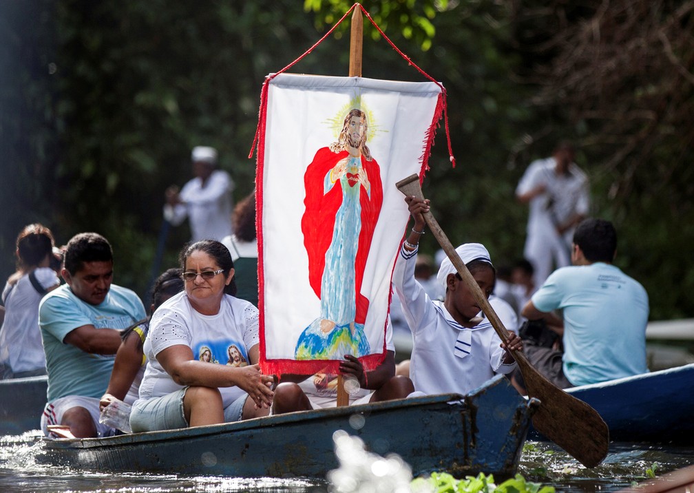 Peregrinos católicos exibem faixa com uma imagem de Jesus durante uma viagem de barco em Santa Izabel do Pará, no Pará, em 2012. — Foto: Paulo Santos/Arquivo/Reuters