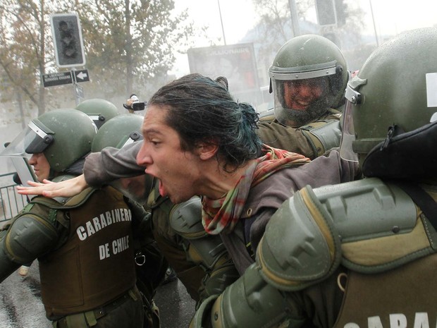 Estudante é detido nesta quinta-feira (26) durante manifestação em Santiago, no Chile (Foto: CLAUDIO REYES / AFP)