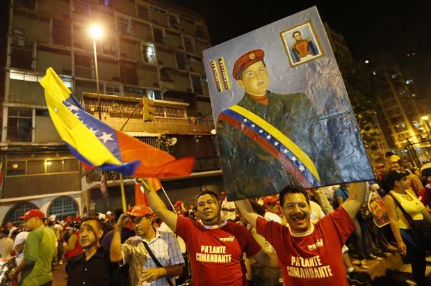 Chavistas reúnem-se em frente ao palácio de Miraflores, em Caracas, celebrando antecipadamente a vitória nas eleições deste domingo (7) (Foto: AP)