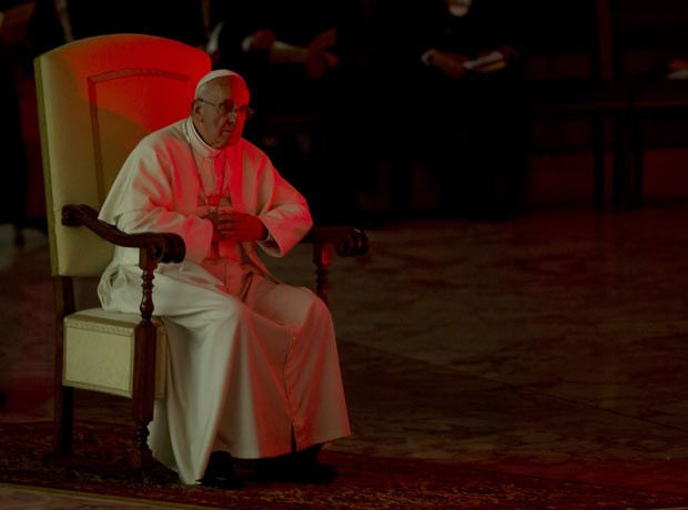 O Papa Francisco é iluminado por luz vermelha durante evento no Salão Paulo VI, no Vaticano, em junho (Foto: AP)