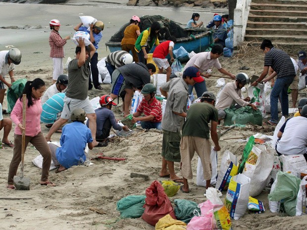 Moradores preparam sacos de areia para reforçar um dique do mar na província de Phu Yen, no Vietnã (Foto: Vietnam News Agency/AFP)