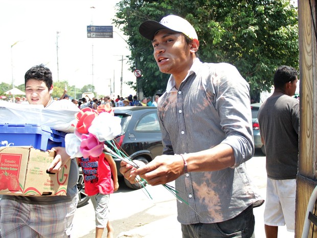 Jovem vende flores na frente de cemitério em Manaus (Foto: Ísis Capistrano/G1 AM)