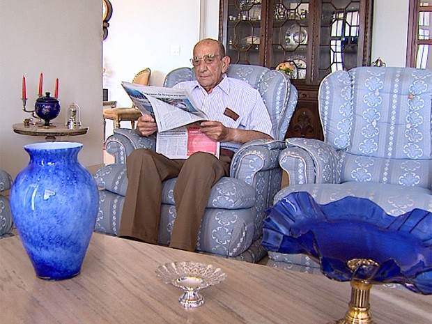 Diariamente, após o café da manhã, o aposentado de 103 anos lê todas as páginas do jornal (Foto: Cláudio Oliveira/EPTV)